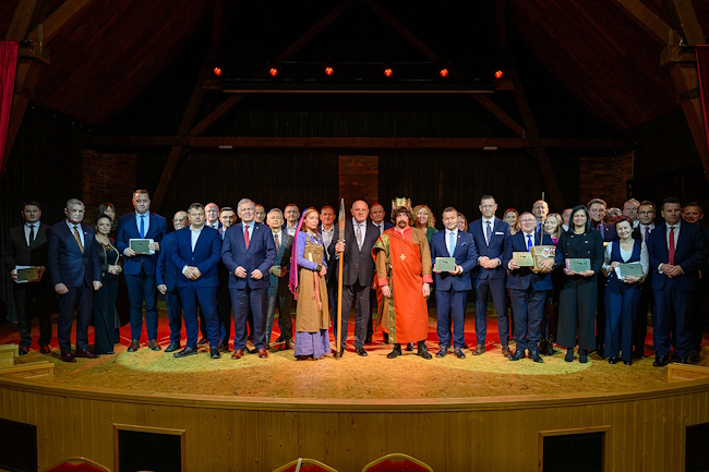 Zarząd Powiatu oraz przedstawiciele wszystkich gmin z pamiątkowymi tabliczkami na scenie w dworku Paderewskiego