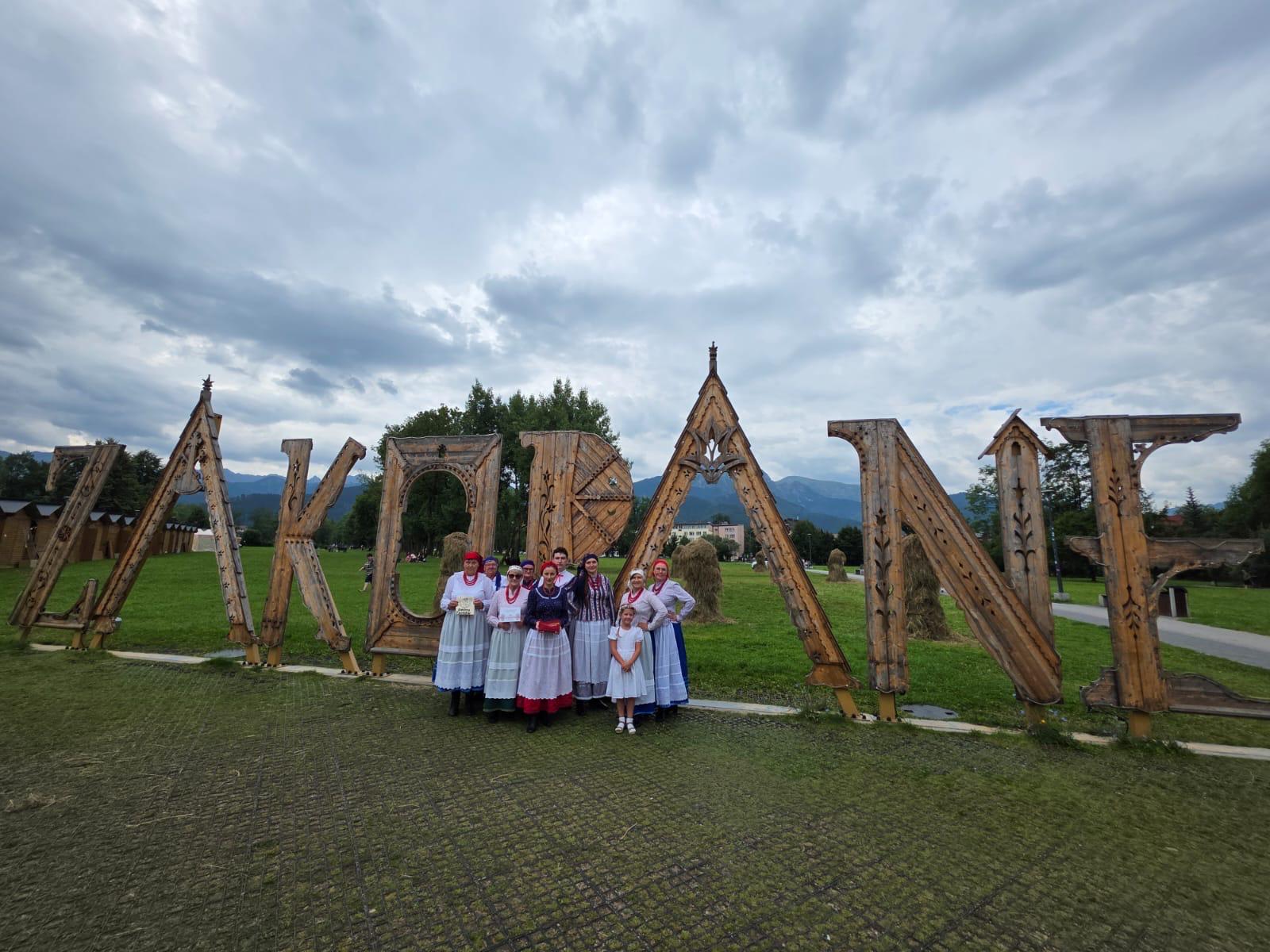 KGW pozuje przy słynnym napisie "Zakopane" na tle gór